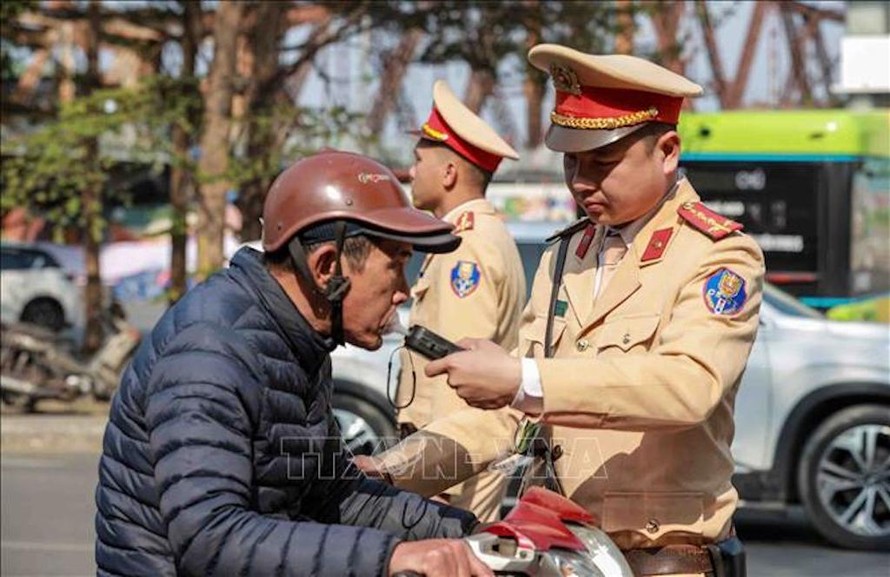 Cán bộ, chiến sĩ đội CSGT số 1 kiểm tra nồng độ cồn của người tham gia giao thông tại tuyến đường Trần Nhật Duật, quận Hoàn Kiếm. 