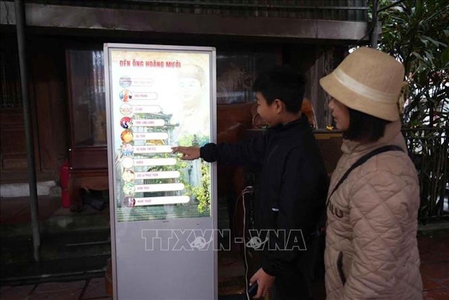 Du khách sử dụng hệ thống kiosk để tìm hiểu thông tin về di tích Đền Ông Hoàng Mười. 