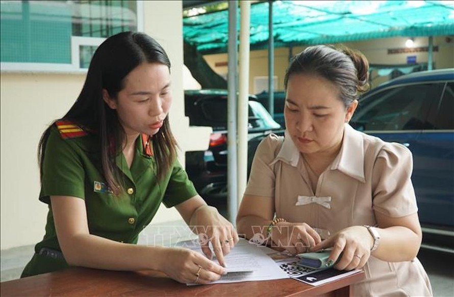 Cán bộ Công an phường Bình Thọ hướng dẫn làm thủ tục cho người dân. 