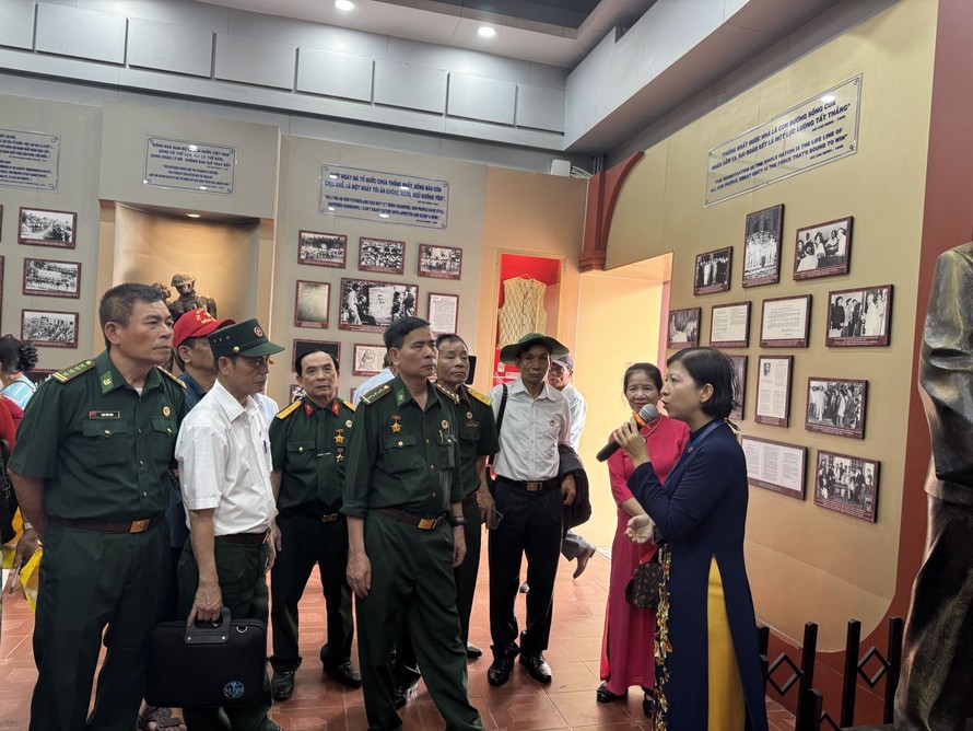 Đông đảo người dân và du khách chăm chú lắng nghe thuyết minh về cuộc đời Bác Hồ.