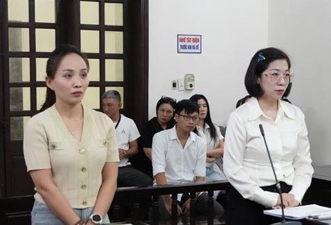 Hai bị cáo Hoàng Kim Ngân (áo dài trắng) và Phạm Thị Lan Hương tại phiên tòa. 