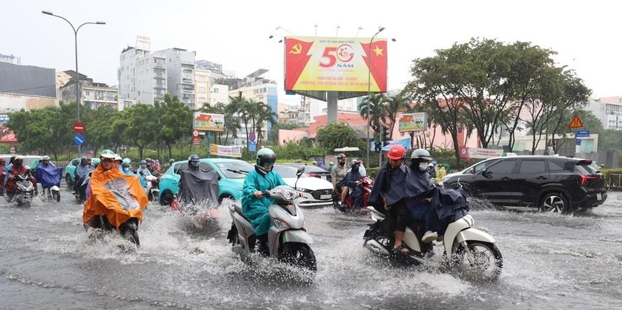 Các phương tiện lưu thông qua ngã tư Nguyễn Thị Nghĩa - Lê Lai, phường Bến Thành, bị ngập sâu trưa 6/10. Ảnh: Hồng Đạt.