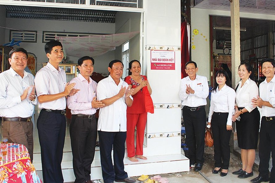 Niềm vui của hộ nghèo bên căn nhà Đại đoàn kết và những phần quà Tết dịp đầu năm. (Ảnh: Báo An Giang) 