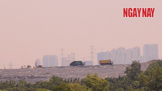 Xe chở rác hoạt động ngày đêm tại Bãi rác Đa Phước. Mỗi lần tấm bạt phủ được mở ra là mùi hôi bao trùm cả khu vực. Ảnh Linh Vũ
