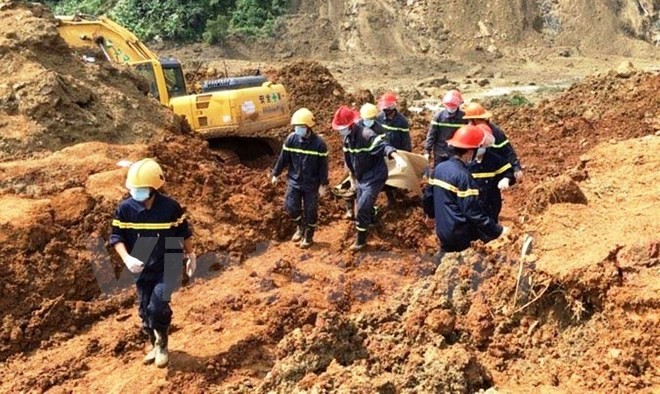 Lực lượng tìm kiếm cứu nạn đưa thi thể các nạn nhân ra khỏi hiện trường. (Ảnh: H.V/Vietnam+)