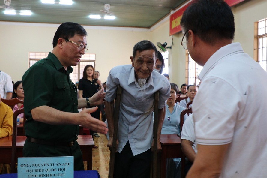 Ông Nguyễn Tuấn Anh – Phó trưởng ban Thường trực Ban Công tác Đại biểu, Đại biểu QH khóa XV tỉnh Bình Phước đang đỡ một cụ già lên nhận quà từ thiện