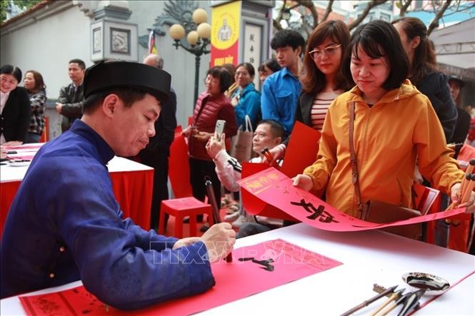 Người dân xin chữ tại buổi lễ. Ảnh: TTXVN