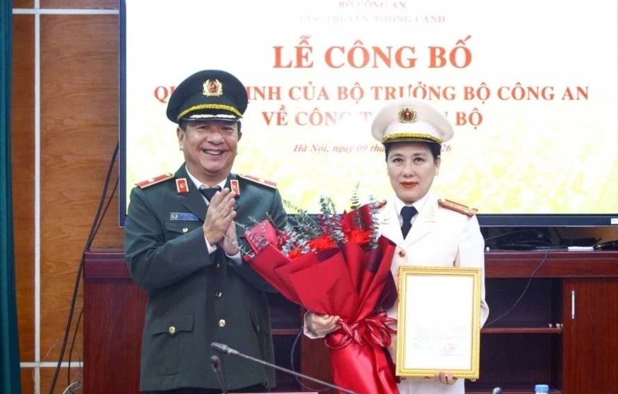 Thiếu tướng Đỗ Triệu Phong trao Quyết định và tặng hoa chúc mừng Đại tá Nguyễn Thị Thu Hằng. Ảnh: CAND