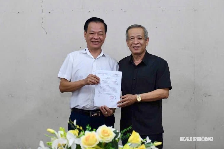 Nghệ sĩ Ưu tú Lê Như Hải (bên phải), Chủ tịch Hội Liên hiệp Văn học Nghệ thuật thành phố trao quyết định chuẩn y ông Nguyễn Đức Nghĩa giữ chức Chủ tịch Hội Nhiếp ảnh Hải Phòng. (Ảnh: Báo Hải Phòng).