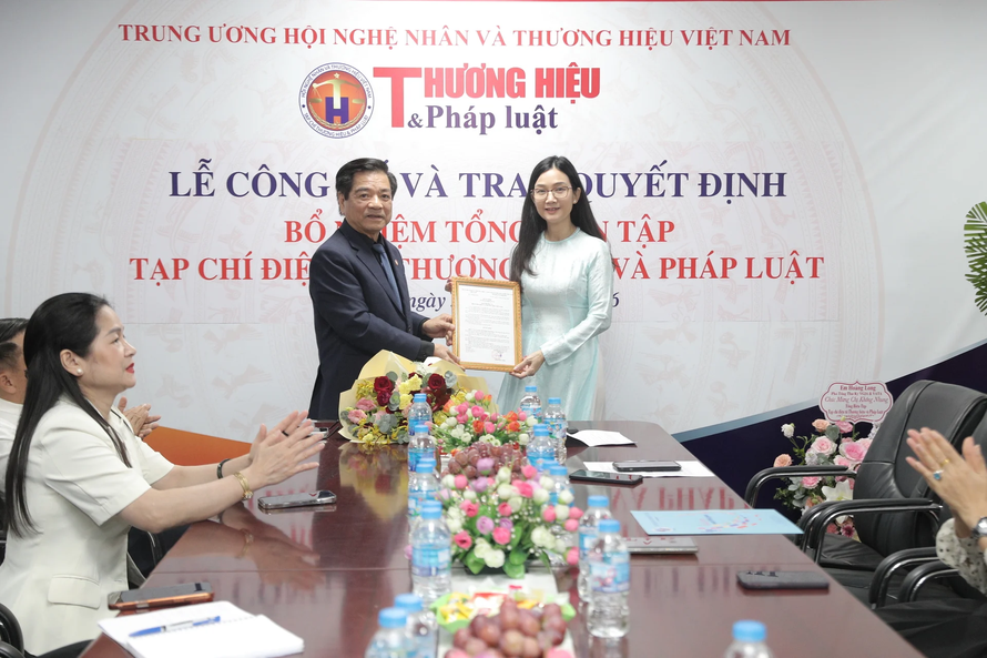 Nhà báo Khổng Nhung nhận quyết định bổ nhiệm Tổng biên tập Tạp chí điện tử Thương hiệu và Pháp luật. Ảnh: TH&PL