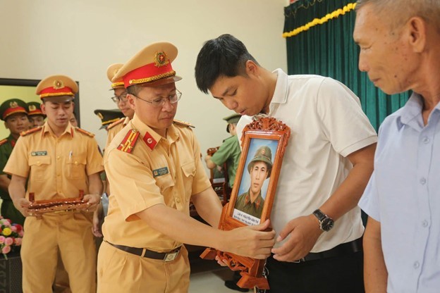Lãnh đạo phòng Cảnh sát giao thông Công an tỉnh Quảng Trị trao tặng di ảnh liệt sĩ Nguyễn Văn Thi cho thân nhân gia đình.