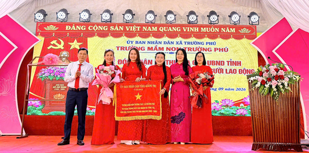 Lãnh đạo sở Giáo dục Quảng Trị và UBND xã Trường Phú trao cờ và tặng hoa chúc mừng tập thể trường mầm non Trường Phú.