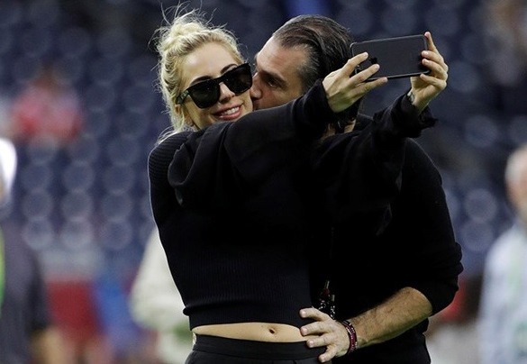 Lady Gaga chụp ảnh tình tứ cùng bạn trai Christian Carino trên sân khấu sự kiện Super Bowl vào cuối tuần trước. Ảnh: ET Online w