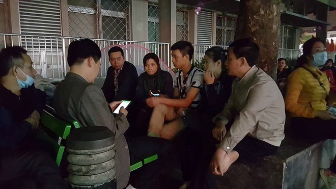 Người nhà bệnh nhân (người mặc áo cộc tay ngồi giữa) trình bày sự việc với phóng viên tại Bệnh viện Bạch Mai tối ngày 6/3.