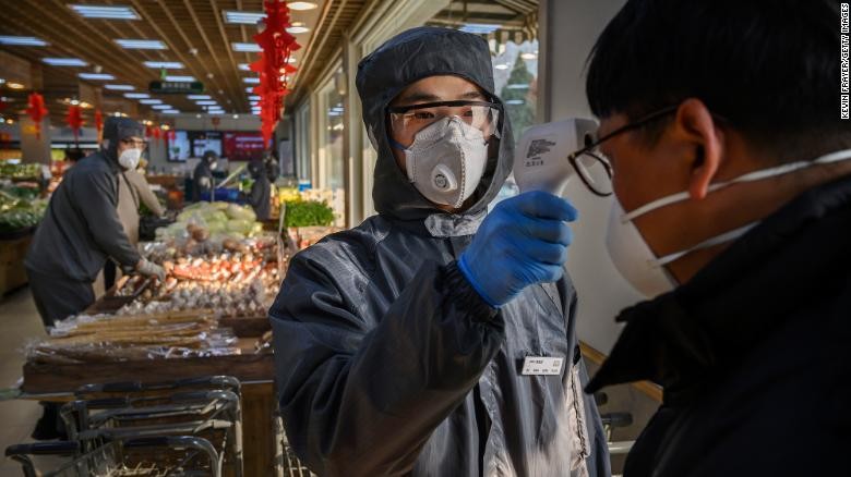 Khách hàng đi siêu thị tại Bắc Kinh được kiểm tra nhiệt độ. Ảnh: CNN