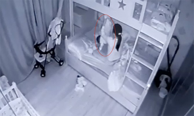 Hình ảnh bé gái 13 tháng tuổi bị bảo mẫu cầm chân dốc ngược - Ảnh cắt từ clip