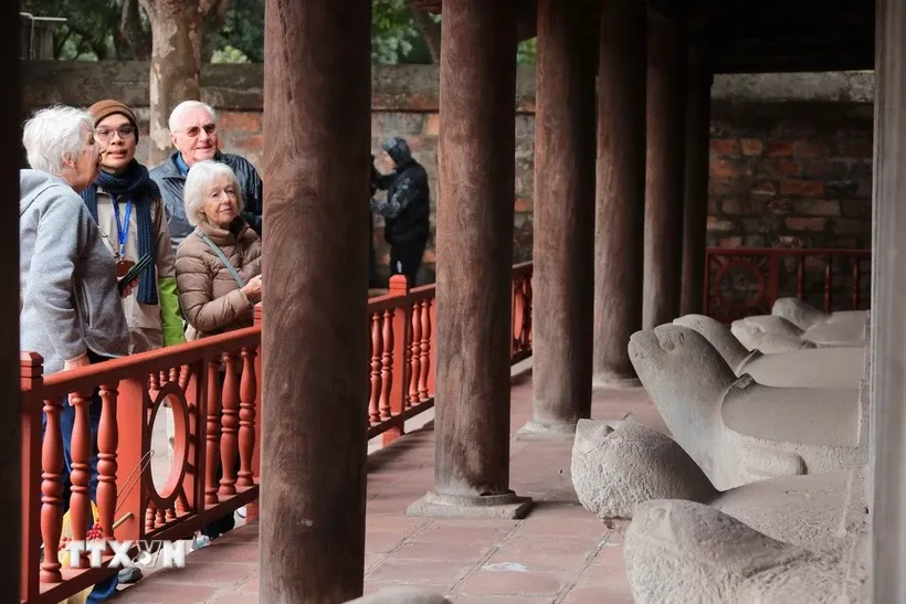 Du khách quốc tế tham quan khu nhà bia lưu danh các tiến sỹ tại Văn Miếu-Quốc Tử Giám. Ảnh: Hoàng Hiếu/TTXVN.