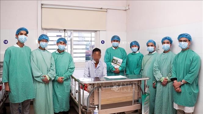 Ekip y bác sĩ Bệnh viện Trung ương Huế thực hiện ca phẫu thuật và bệnh nhân. Ảnh: TTXVN