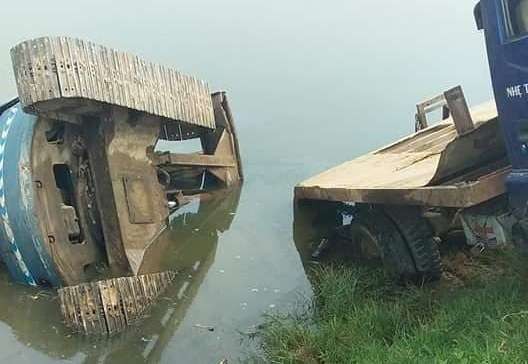 Máy xúc và xe tải lao xuống ao