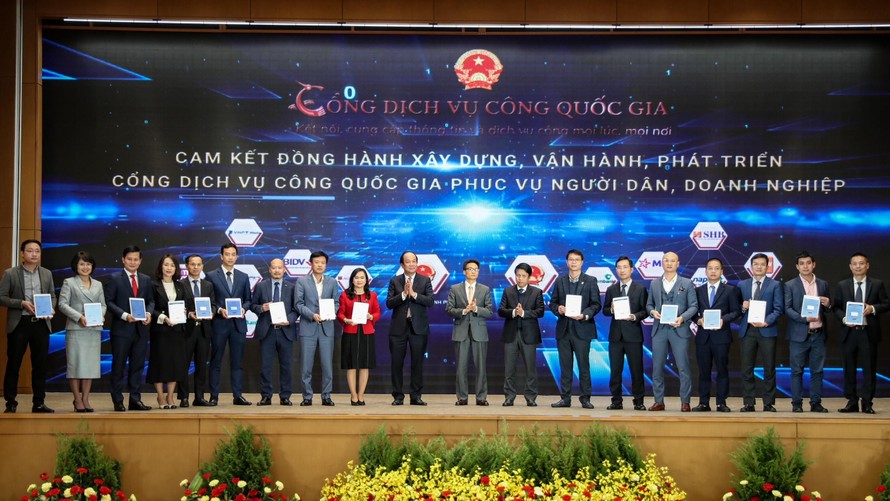 Phó Tổng giám đốc VPBank Đinh Văn Nho (thứ 5 từ trái sang) và các doanh nghiệp ký cam kết đồng hành xây dựng, phát triển Cổng Dịch vụ công quốc gia. (Ảnh: Minh Sơn/Vietnam+)