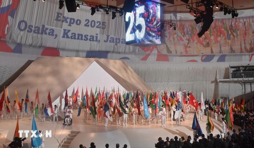 Học sinh Trung học phổ thông Osaka diễu hành với cờ của các quốc gia tham dự EXPO 2025 trong lễ khai mạc. Ảnh: Phạm Tuân/TTXVN.