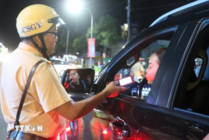 Cán bộ chiến si Đội Cảnh sát giao thông Công an thành phố Long Xuyên kiểm tra ngẫu nhiên nồng độ cồn đối với người tham gia giao thông. Ảnh: Công Mạo/TTXVN