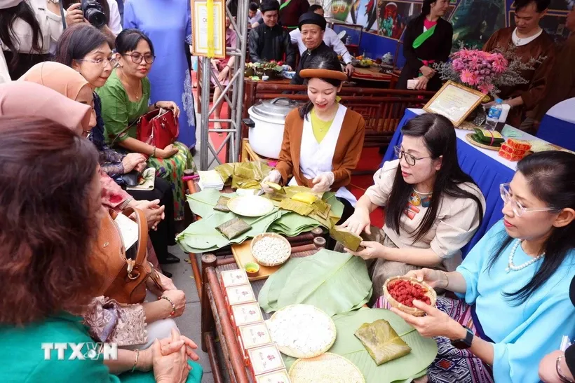 Bà Lê Thị Bích Trân, Phu nhân Thủ tướng Chính phủ Phạm Minh Chính và nhóm Phụ nữ cộng đồng ASEAN tại Hà Nội trải nghiệm làm bánh phu thê. Ảnh: Phạm Kiên/TTXVN