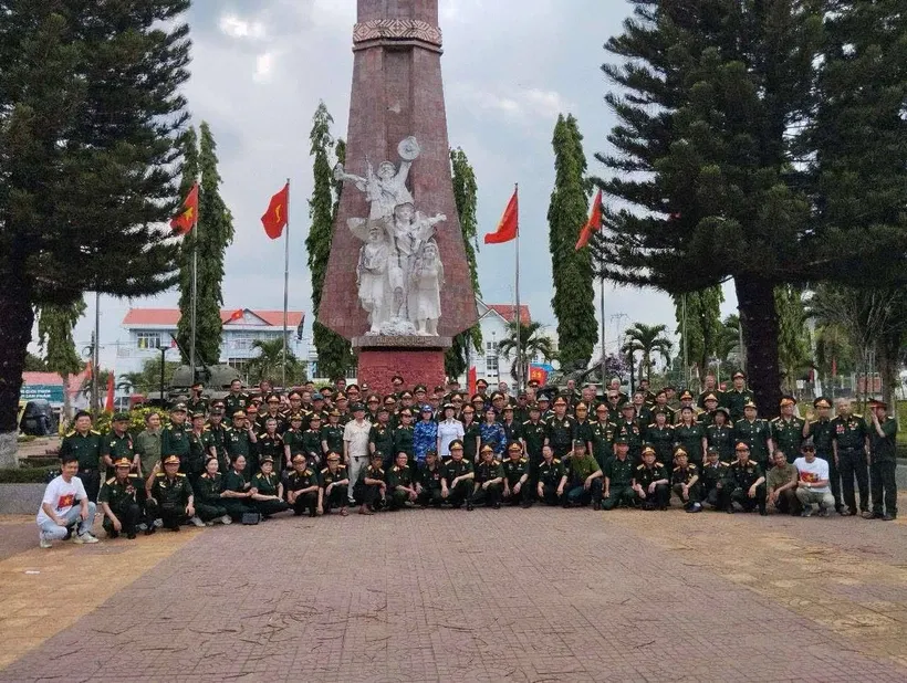 Đoàn cựu chiến binh phía Bắc chụp ảnh kỷ niệm tại Đài tưởng niệm Đăk Tô. Nguồn: Vietnam+