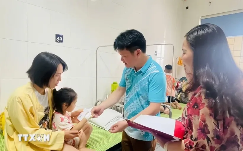 Lãnh đạo thành phố Cao Bằng thăm hỏi các em nghi bị ngộ độc thực phẩm được điều trị tại Bệnh viện đa khoa tỉnh. Ảnh: TTXVN 