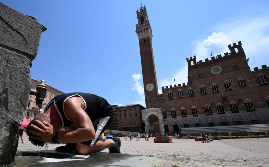Một người đàn ông làm mát tại đài phun nước ở Siena, Italy.