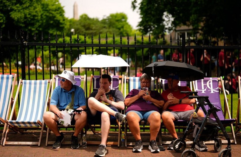 Người dân dùng ô che nắng ở London.