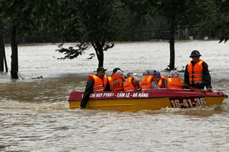 Lực lượng chức năng dùng ca nô đưa người dân ra khỏi vùng ngập lũ nguy hiểm. 