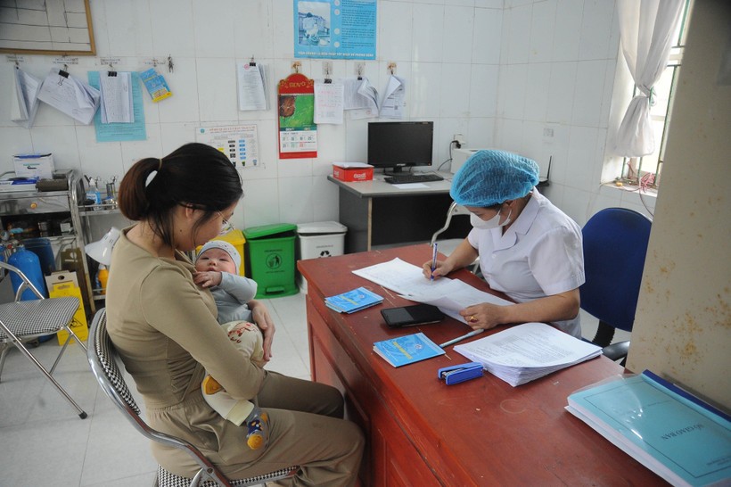 Nhân viên y tế khám sàng lọc, kiểm tra tình trạng của trẻ trước khi tiêm vaccine. Ảnh: Vũ Quang/TTXVN.