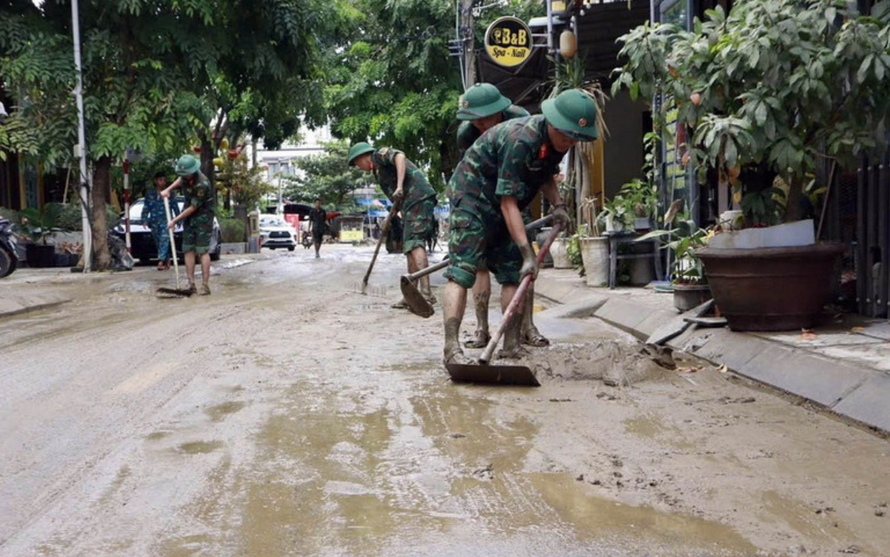 Bộ đội giúp nhân dân làm sạch, thu gom rác thải, tẩy rửa môi trường.