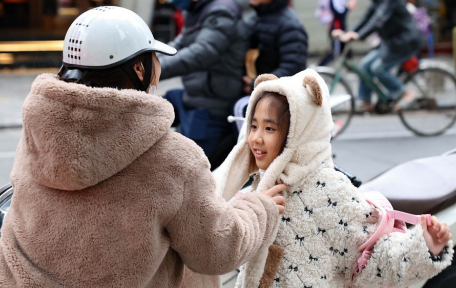 Trẻ em được giữ ấm khi lưu thông bằng xe máy trong những ngày rét đậm