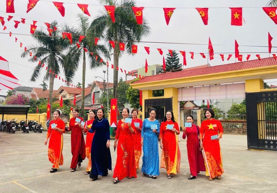 Chị em hội viên phụ nữ xã Tiến Thắng mặc áo dài đi bầu cử.