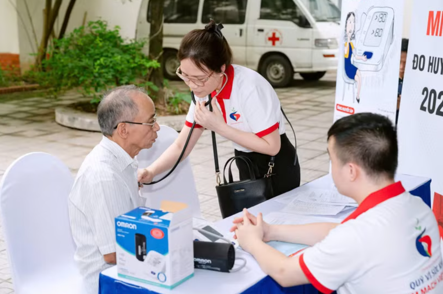 Nhân viên y tế đo huyết áp cho người dân tại Chương trình khám, tư vấn bệnh miễn phí.