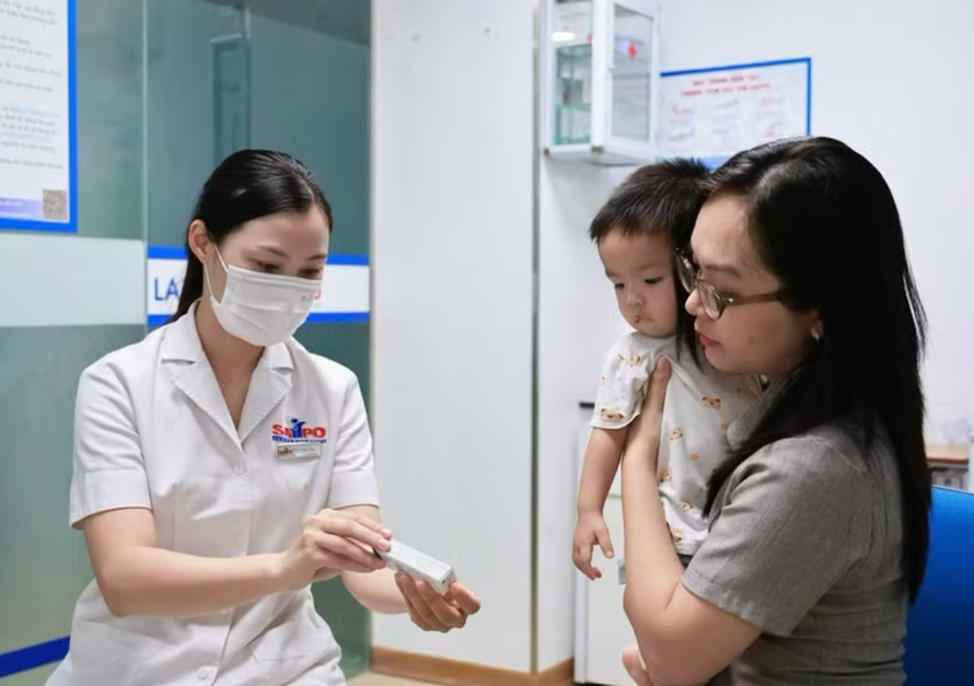 Phụ huynh đưa trẻ đi tiêm vaccine.
