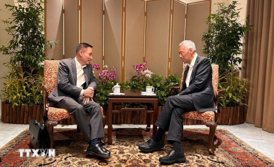 Trưởng Ban Đối ngoại Trung ương Lê Hoài Trung chào xã giao Bộ trưởng Cấp cao Lý Hiển Long. Ảnh: TTXVN phát