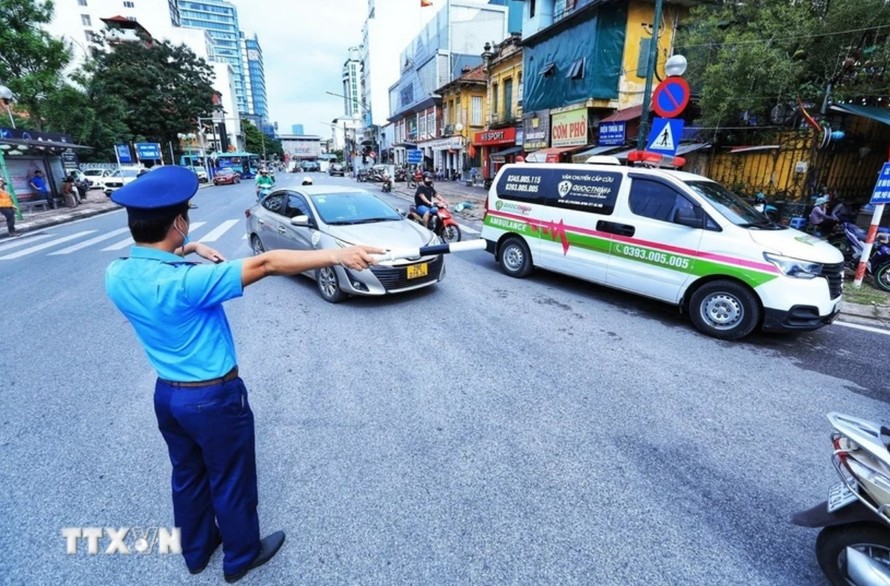Vượt đèn đỏ để nhường đường cho xe cấp cứu, xe ưu tiên trong trường hợp tình thế cấp thiết sẽ không bị xử phạt vi phạm hành chính. Ảnh: Tuấn Anh/TTXVN