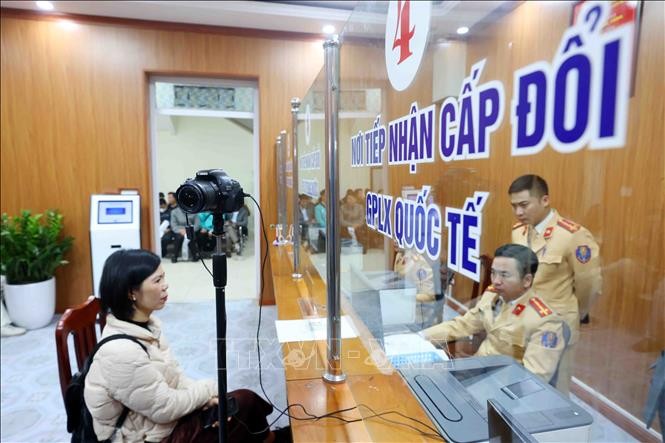 Cán bộ, chiến sĩ Đội Sát hạch, cấp giấy phép lái xe cơ giới đường bộ (Phòng Cảnh sát giao thông, Công an thành phố Hà Nội) làm thủ tục cấp, đổi giấy phép lái xe cho công dân. Ảnh: Phạm Kiên/TTXVN