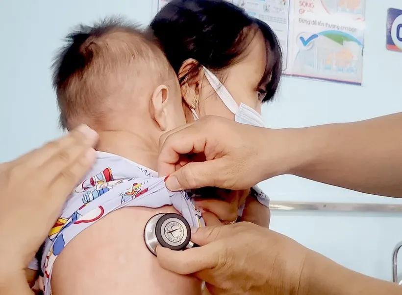 Bác sĩ thăm khám, điều trị cho trẻ mắc bệnh sởi. Ảnh: TTXVN/Vietnam+