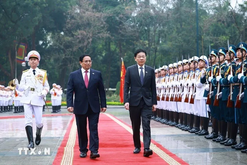 Thủ tướng Phạm Minh Chính và Thủ tướng Singapore Lawrence Wong duyệt Đội danh dự Quân đội nhân dân Việt Nam. Ảnh: Dương Giang/TTXVN