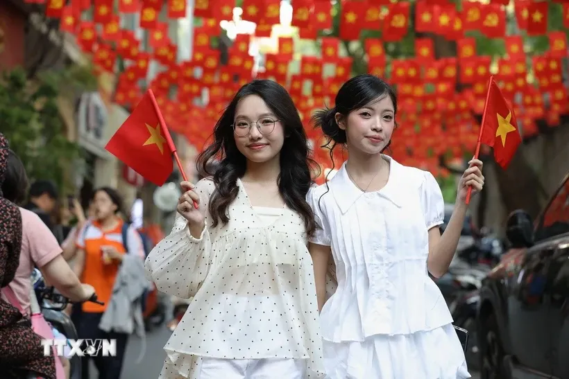 Phố Ấu Triệu với những dải cờ đỏ sao vàng tung bay, thu hút đông đảo bạn trẻ đến chụp ảnh để hòa chung không khí kỉ niệm dịp lễ 30/4. Ảnh: Lê Đông/TTXVN