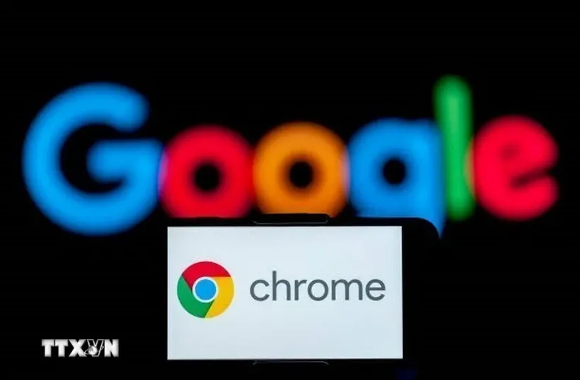 Biểu tượng Chrome trên màn hình điện thoại và biểu tượng Google (phía sau). Ảnh: Getty Images/TTXVN