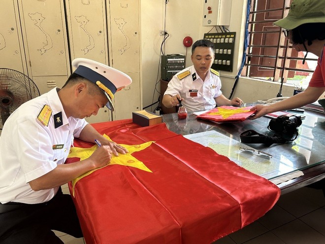 Các chiến sỹ đảo Trường Sa đóng dấu, ký tên trên lá cờ Tổ quốc cho các đại biểu mỗi khi có đoàn công tác đến làm việc.