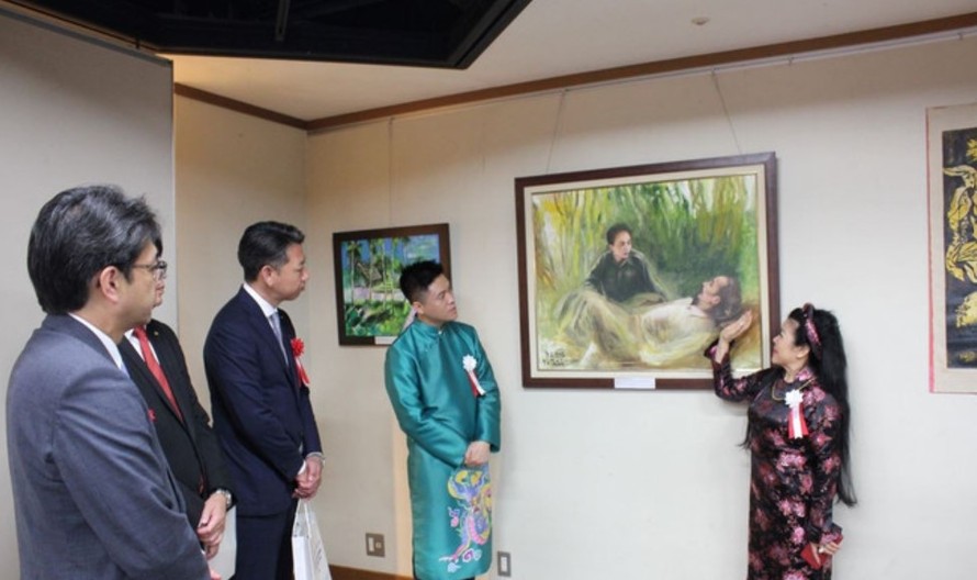 Nữ họa sỹ Văn Dương Thành giới thiệu tranh vẽ về Chủ tịch Hồ Chí Minh. Ảnh: Phạm Tuân