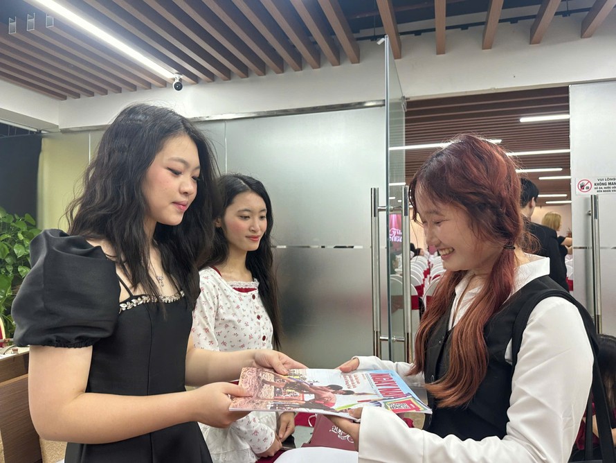 Các độc giả trẻ hào hứng nhận và đọc báo giấy của Tạp chí Ngày Nay.