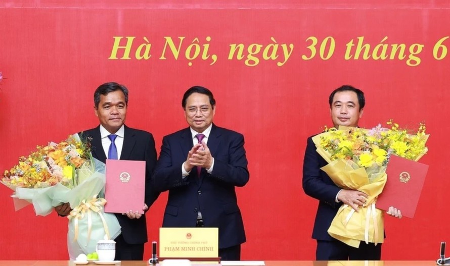 Thủ tướng Phạm Minh Chính trao quyết định và tặng hoa chúc mừng đồng chí Trần Đức Thắng (phải), Phó Tổng Thanh tra Thường trực Thanh tra Chính phủ và đồng chí Hồ Văn Niên, Thứ trưởng Thường trực Bộ Dân tộc và Tôn giáo. Ảnh: Dương Giang