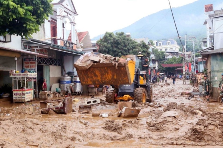 Máy xúc được huy động để hỗ trợ san gạt, thu gom bùn đất, cành cây, rác bị tràn về trong đợt lũ vừa qua tại xã Sông Mã. Ảnh: Quang Quyết